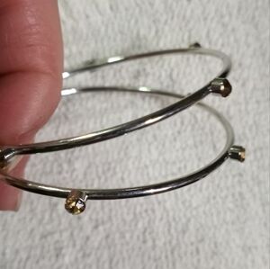 Pair of silvertone bangle bracelets with amber color crystals